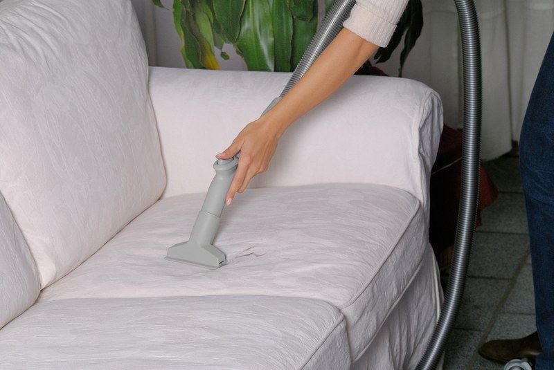 Dùng máy hút bụi vệ sinh bụi bẩn sofa nỉ